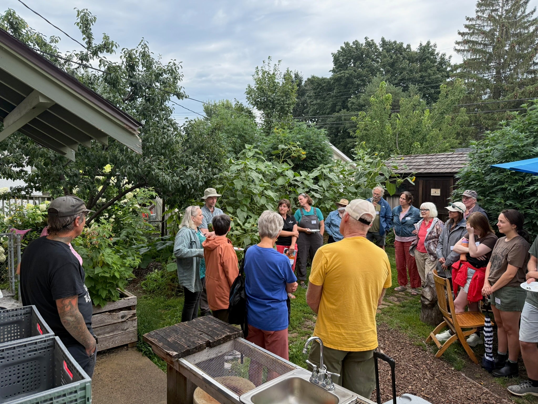 Group of people gathered around our backyard where we have CSA pickup of hyperlocal produce in The Black Radish CSA building.